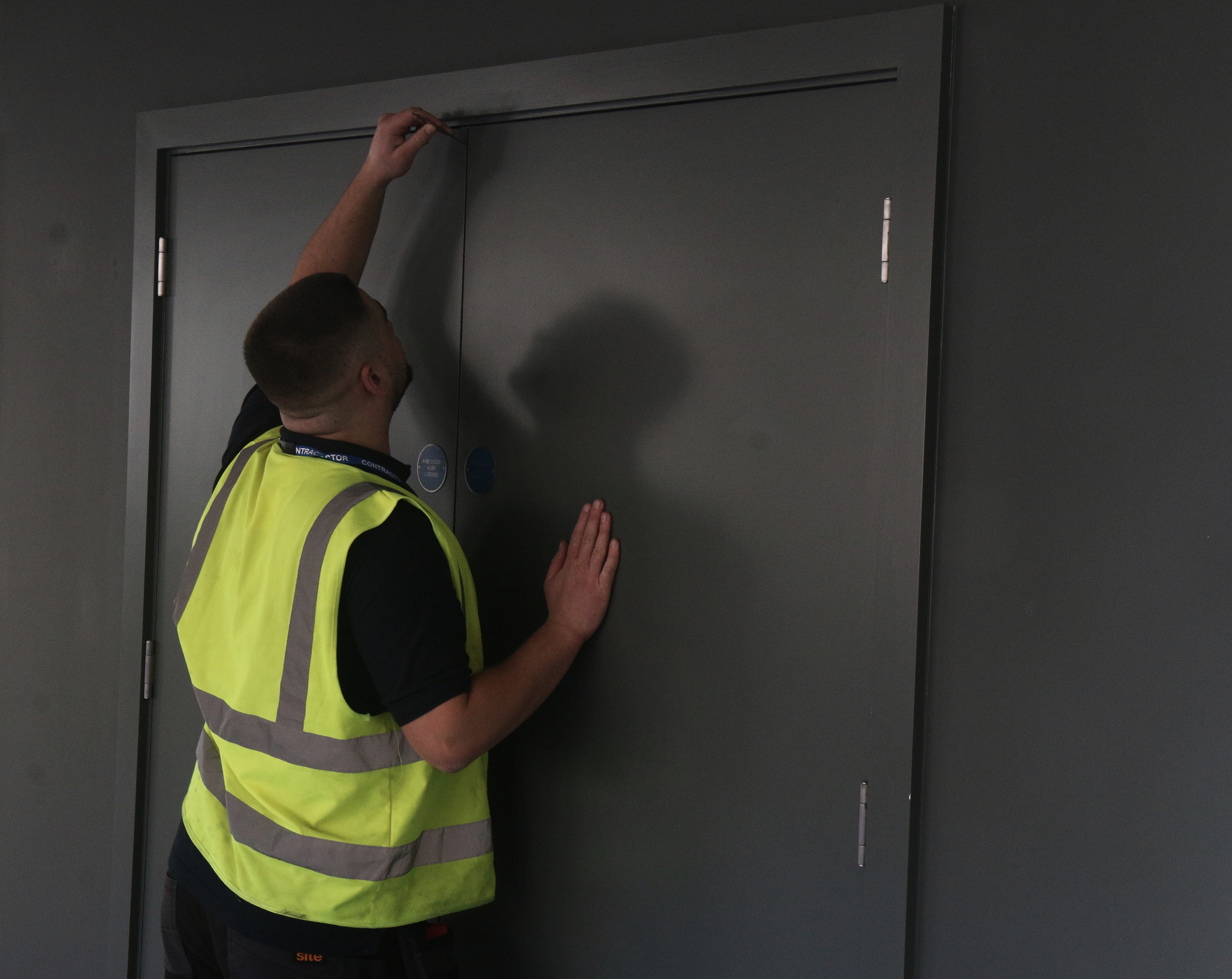 Harry inspecting a fire door